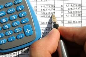A person holding a pen and a calculator - 5 Steps to Creating a Killer Business Budget