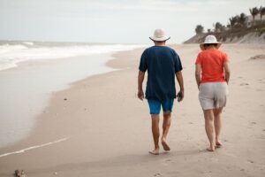 Couple Walking On Beach - Retiring in Another State